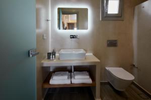 La salle de bains est pourvue d'un lavabo, de toilettes et d'un miroir. dans l'établissement Acropole Sunrise, à Kamari