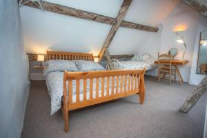 a bedroom with a wooden bed and a table at Reckless House. Forest Of Dean.Home Whilst Away. in Coleford