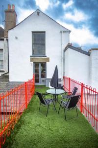 a patio with a table and chairs in front of a building at Reckless House. Forest Of Dean.Home Whilst Away. in Coleford