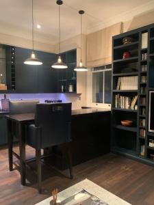 una cocina con armarios negros, mesa y sillas en Charming and full of character en Londres