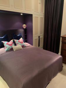 a bedroom with a large bed with purple walls at Charming and full of character in London