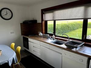 a kitchen with a sink and a window at Immaculate 5 Bedroom House with Sea View in Stornoway