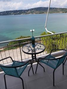 a table and chairs on a balcony with a view of the water at Orion front sea apartment in Theologos
