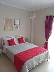 a bedroom with a large bed with red pillows at Orion front sea apartment in Theologos