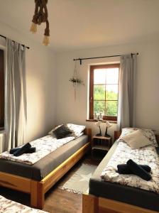a bedroom with two beds and a window at SielskoAnielsko w Beskidzie Niskim in Męcina Wielka