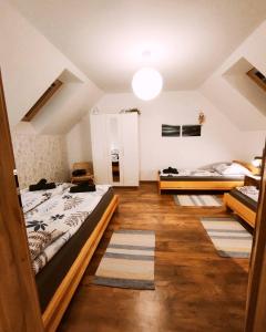 two beds in a room with wooden floors at SielskoAnielsko w Beskidzie Niskim in Męcina Wielka