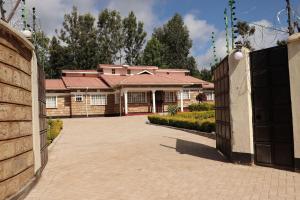 a house with a gate in front of a driveway at The Meru Manor in Meru