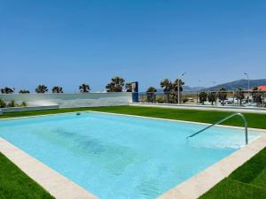 duży basen w ogrodzie z trawą w obiekcie Precioso apartamento con vistas parciales, garaje y piscina w mieście Tarifa