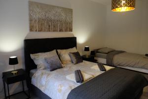 a bedroom with two beds and a painting on the wall at Apartman Gold in Požega