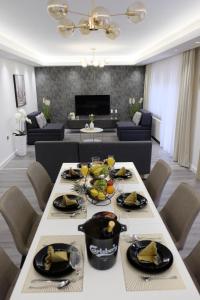 a dining room with a table and a living room at Apartman Gold in Požega