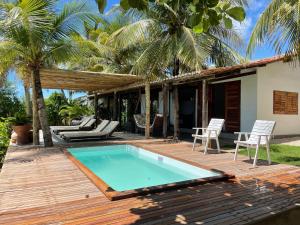 a house with a swimming pool on a wooden deck at Casa Mandakarú in Icapuí