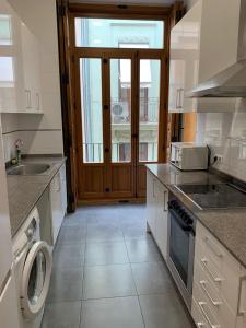a kitchen with a sink and a stove at Apartment Plaza de la Merced in Valencia