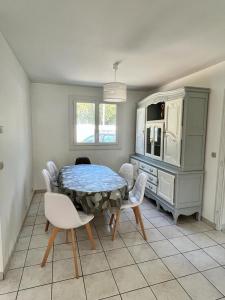 comedor con mesa y sillas blancas en A L'orée du Bois, en LʼÉguille