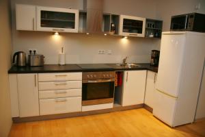 a kitchen with white cabinets and a white refrigerator at Kuressaare Holiday Apartments in Kuressaare