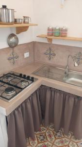 una cucina con piano cottura e lavandino di La casa dei nonni a Pantelleria