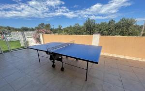 a ping pong table sitting on top of a patio at Joli Chalet avec grande terrasse et accès piscine in Rocbaron