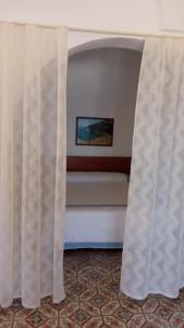 a bed with a curtain in a room at La casa dei nonni in Pantelleria