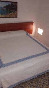 uma grande cama branca num pequeno quarto em La casa dei nonni em Pantelleria