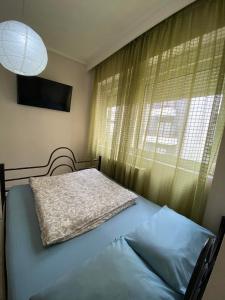 a bedroom with a bed and a window with a lamp at Central Apartment Thessaloniki-Easy Parking in Thessaloniki