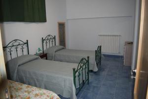 1 dormitorio con 3 camas y suelo de baldosa azul en Nel Verde per Mare e Terme, en Guardia Piemontese Terme