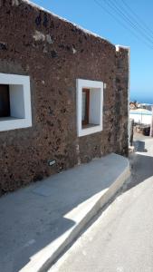 Una pared de ladrillo con dos ventanas en el lateral. en La casa dei nonni, en Pantelleria