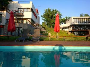 una piscina con 2 sombrillas rojas y un edificio en "7 terrass" бутик-отель en Samara