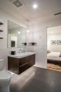 un bagno con lavandino, servizi igienici e un letto di Elevation Lofts Hotel ad Asheville