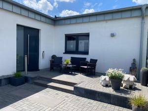 a white house with a patio with a table and chairs at BÖ21 Luxusappartement in Büttgen