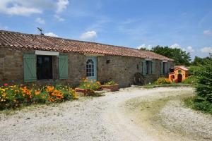 a stone house with flowers in front of it at Gîte de La Pomerie in Chiché