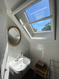 uma casa de banho com um lavatório e uma janela em Appartement Oosteinde em Ruinerwold