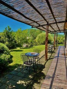 een patio met een tafel en stoelen onder een pergola bij Agriturismo Colleverde Capalbio in Capalbio