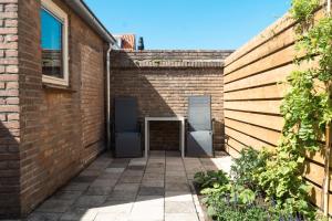 a brick alley with two doors in a brick wall at Zomerhuis aan Zee in Noordwijk aan Zee