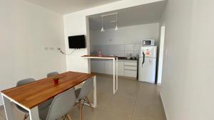 a kitchen with a wooden table and a refrigerator at Las Cuatro Estaciones in Esquel +5 photos