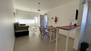 a kitchen and living room with a table and chairs at Las Cuatro Estaciones in Esquel