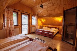 Tempat tidur dalam kamar di Pensiunea Poienita Ursului