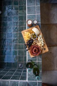 a cutting board with food and two bottles of beer at Zero Meia Um Pousada in São Miguel do Gostoso