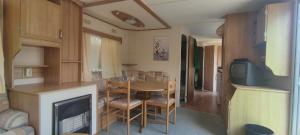 a dining room with a table and a fireplace in a caravan at Zacisze nad Sanem 129 a in Załuż