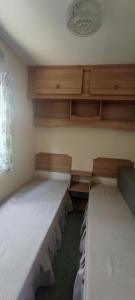 a room with two empty beds and wooden cabinets at Zacisze nad Sanem 129 a in Załuż
