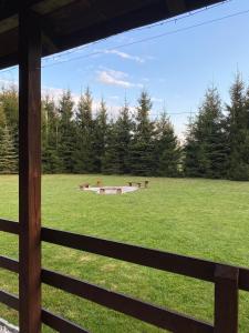 Blick auf ein Feld von einem Zaun in der Unterkunft Domek drewniany z kominkiem in Tomczyn