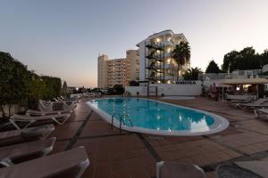 a large swimming pool with chairs and a building at TC Apartamentos Don Diego in Playa del Ingles