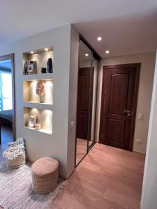 Cette chambre dispose d'un couloir avec un miroir et une porte. dans l'établissement Apartamentai Forest green, à Nido