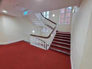 a staircase with a red carpet in a house at Birch Hill Clock Tower in Rochdale