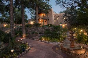 a home with a garden with a fountain and lights at Inn of the Turquoise Bear in Santa Fe