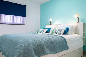 een blauwe slaapkamer met een groot bed met kussens bij Dimore Italiane - Boutique Apartments in Corralejo