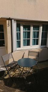 deux chaises et une table devant un bâtiment dans l'établissement F2 RDC promo cour Courseulles sur mer, à Courseulles-sur-Mer