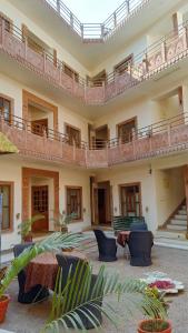 un grand bâtiment avec des chaises et des tables ainsi qu'un balcon dans l'établissement Rigmor haveli, à Jodhpur