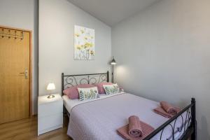sypialnia z dużym łóżkiem z różowymi poduszkami w obiekcie Apartment LaMaro w mieście Kaštela