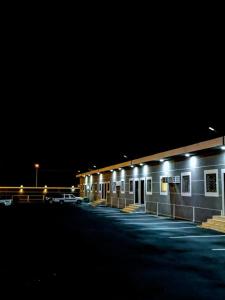 un parking avec une rangée de bâtiments la nuit dans l'établissement وحدات سكنية الحصون, à Ithnayn