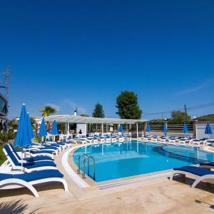 a large swimming pool with chairs and blue umbrellas at Bodega Butik Otel Şile in Sile