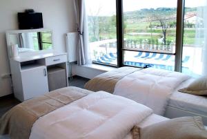 a hotel room with two beds and a large window at Bodega Otel Şile in Şile